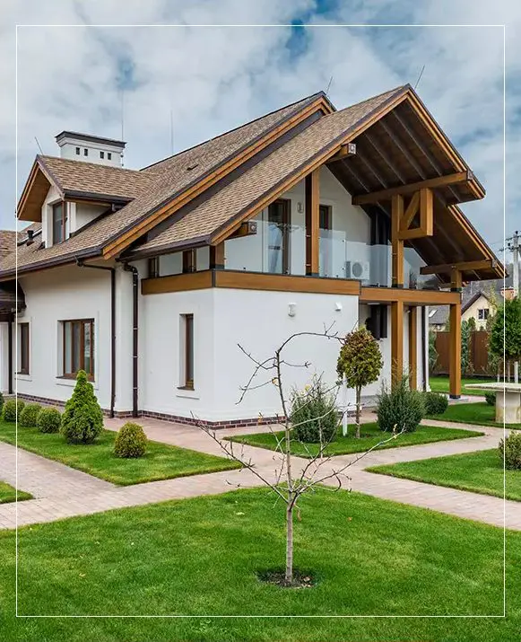 A white and brown house with a green lawn.